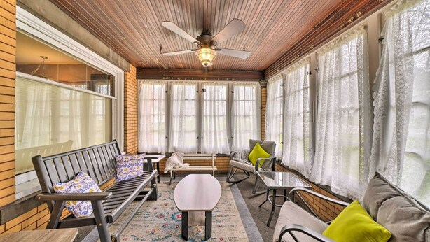 A sunroom with wooden ceiling, large windows, a ceiling fan, and furnished seating areas. - Classy Colonial House w/ Furnished Sunroom! (North Lima)