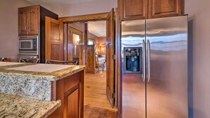 A kitchen with wooden cabinets, a stainless steel refrigerator, and a granite countertop. - Classy Colonial House w/ Furnished Sunroom! (North Lima)