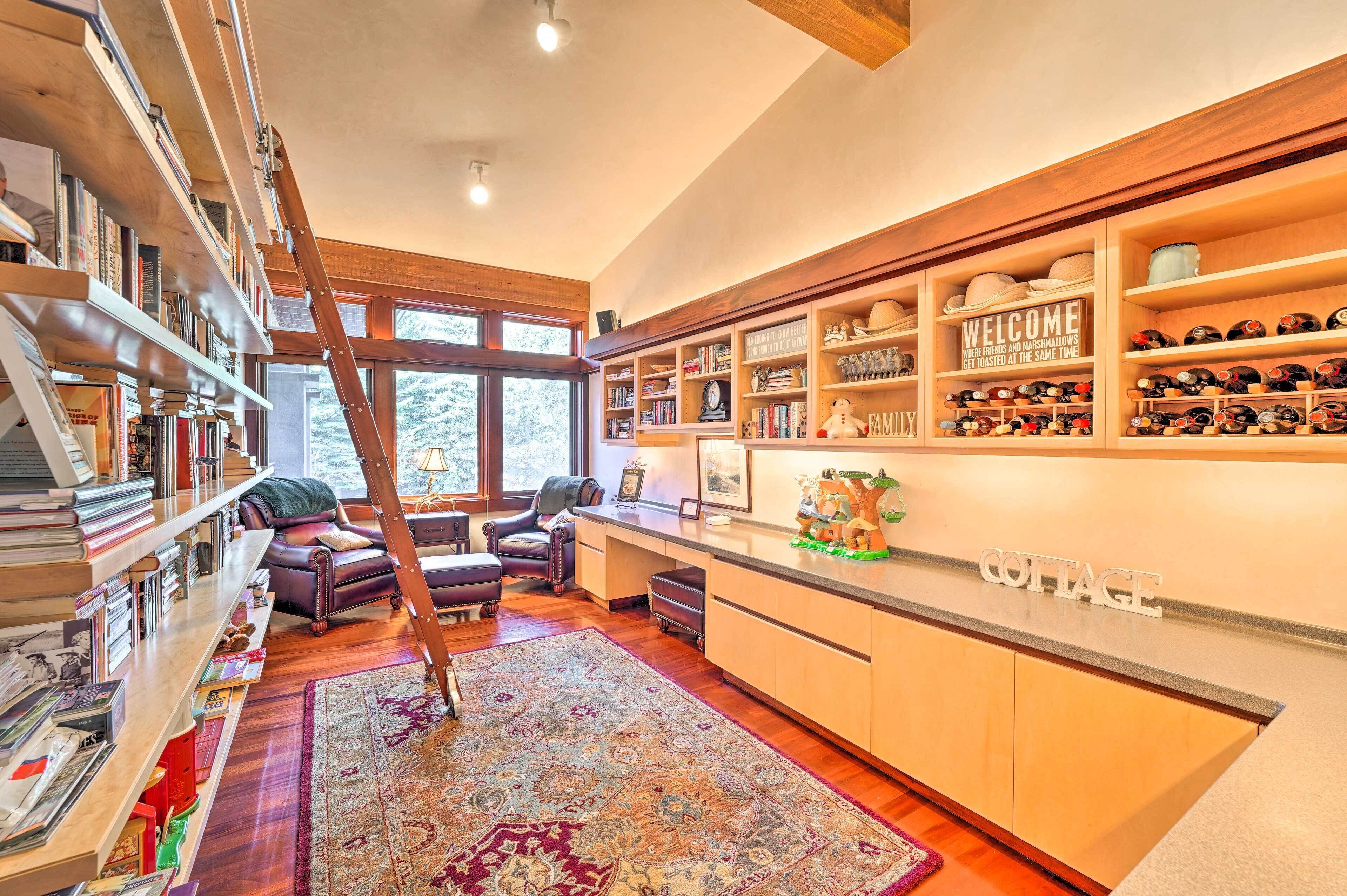 A cozy library with bookshelves, a leather chair, a wooden ladder, and a 'Welcome' sign.