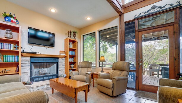 A cozy living room with a fireplace, comfortable seating, and a television. - Deck & Gas Grill: Riverfront Mcqueeney Duplex (McQueeney)