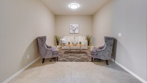 A living room with a sofa, two armchairs, a coffee table, and a rug. - Chic Country Club Condo With Pool Access! (Naples)