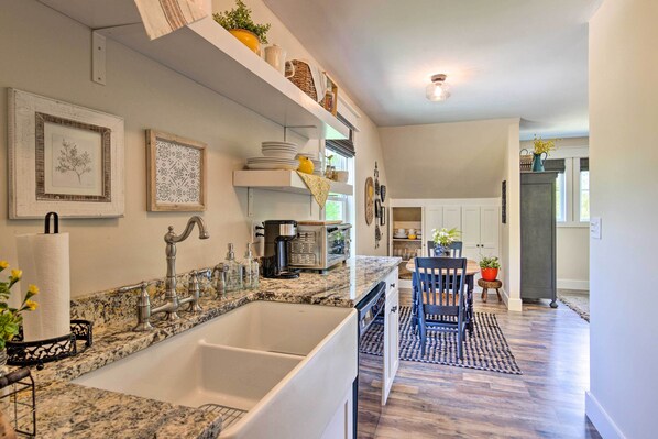 A kitchen with a large white sink, granite countertop, and a dining area with a blue and white patterned rug. - Near Parks, Trails & Lakes: Quaint Landrum Escape! (Landrum)