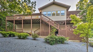 A two-story house with a covered porch and a staircase leading to the upper level. - Deck w/ Bbq: Hot Springs Village Apt! (Hot Springs Village)