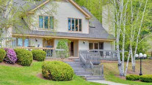 A two-story house with a front porch, a covered entryway, and a small deck. - Charming Jackson Mountain Retreat on Golf Course! (Jackson)