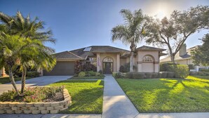 A residential house with a front yard, a driveway, and a well-maintained lawn. - Bright & Sunny Riverview Oasis w/ Pool & Pond (Riverview)