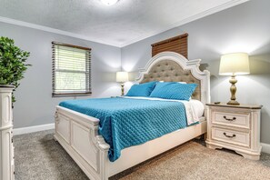 A bedroom with a bed, two bedside tables, a window with blinds, and a potted plant. - Indianapolis Vacation Rental ~ 8 Mi to Downtown! (Indianapolis)