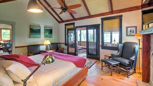 A bedroom with a large bed, a ceiling fan, and a view of the outdoors through a sliding door. - Woodsy Bryson City Cabin w/ Smoky Mountain Views! (Bryson City)