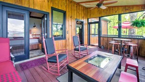 A wooden deck with a glass-top table, rocking chairs, and a ceiling fan. - Woodsy Bryson City Cabin w/ Smoky Mountain Views! (Bryson City)