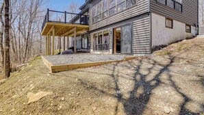 Une maison moderne à deux étages, dotée d’un balcon, de grandes fenêtres et d’une allée gravillonnée.
