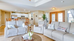A spacious living room with a sofa set, a coffee table, and a ceiling fan.