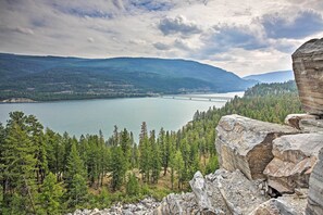 A mountainous landscape with a lake, a bridge, and a rocky outcrop. - West Kootenai Cabin in Amish Country! (Rexford)