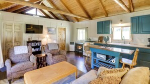 Un accogliente interno di una baita con zona living, cucina e sala da pranzo.