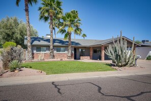 A two-story house with a brick facade, a front lawn, and a large cactus in the yard. - Beautiful Phoenix Vacation Rental w/ Private Pool! (Phoenix)