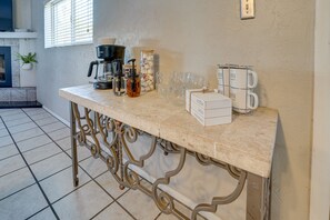 Un comptoir de cuisine avec le matériel nécessaire pour préparer le café, une boîte de café et un porte-tasses.