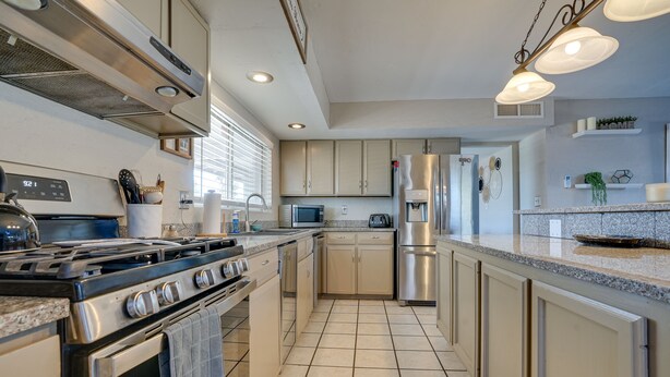 A modern kitchen with stainless steel appliances, a granite countertop, and beige cabinetry. - Beautiful Phoenix Vacation Rental w/ Private Pool! (Phoenix)