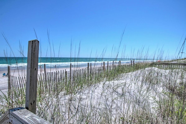 A beach with wooden posts and sand dunes.