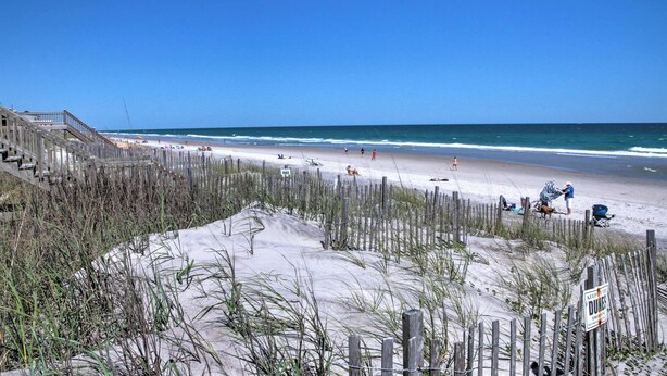 A beach with a wooden fence, a sandy area, and the ocean. - Updated Family Getaway: Walk to Sea Haven Beach! (Sneads Ferry)