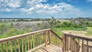 A wooden deck with a view of a natural landscape and distant buildings. - Updated Family Getaway: Walk to Sea Haven Beach! (Sneads Ferry)