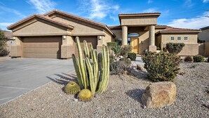 A residential house with a garage, a driveway, and a desert garden with cacti and rocks. - 11 Mi to Phoenix Raceway: Luxury Sonoran Oasis! (Goodyear)