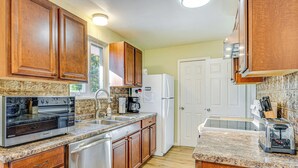 A kitchen with wooden cabinets, a stainless steel refrigerator, a coffee maker, and a toaster. - ~ 10 Mi to Dtwn: Indianapolis Home w/ Game Room! (Indianapolis)