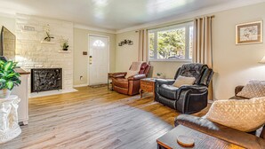 A living room with a fireplace, leather chairs, a sofa, and a dining table. - ~ 10 Mi to Dtwn: Indianapolis Home w/ Game Room! (Indianapolis)