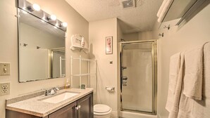 Un baño con lavamanos, espejo y ducha.