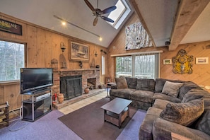 A cozy living room with a fireplace, a large TV, and a comfortable sofa.