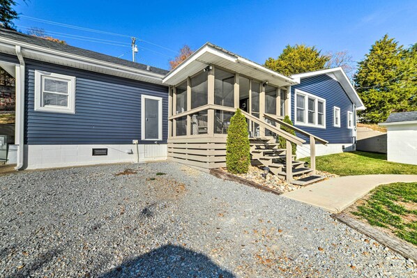 A two-story house with a covered porch and a small staircase leading to the entrance.