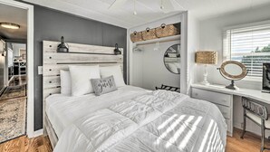 A bedroom with a bed, a desk with a mirror, and a wardrobe.
