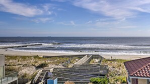 A beach view with a wooden boardwalk leading to the shore, a sandy beach, and the ocean. - Luxury Long Beach Villa With Ocean Views! (Long Beach)