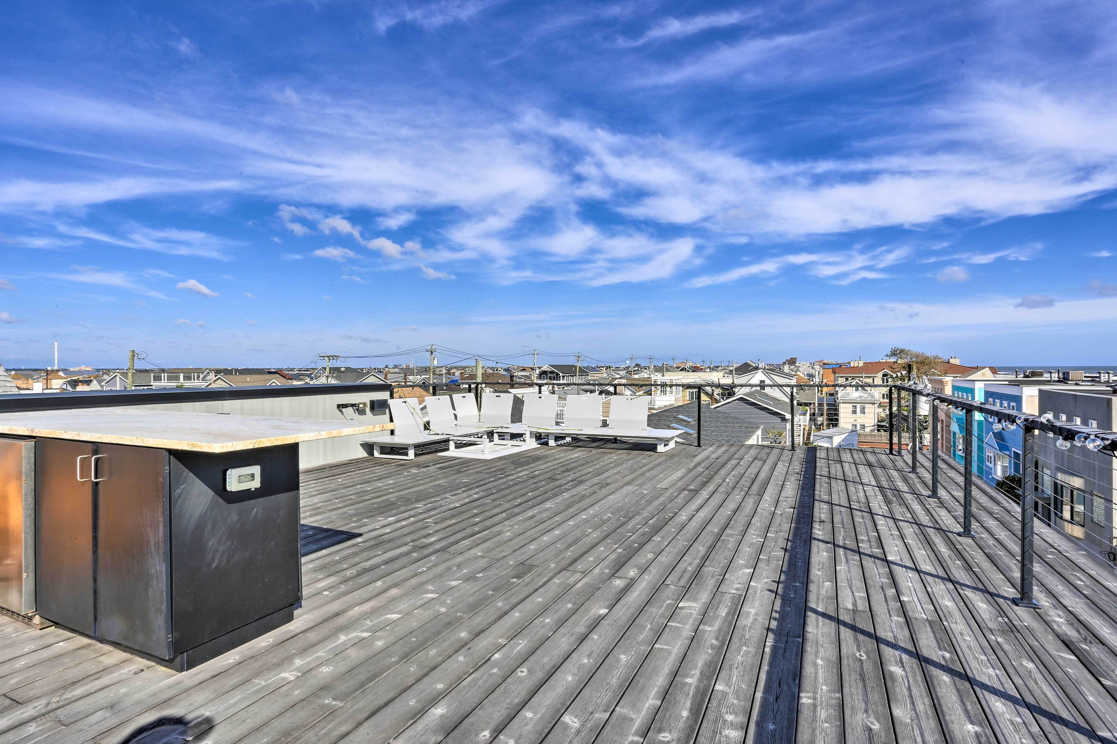 Terraza en la azotea con cubierta de madera, un espacio cerrado pequeño y vistas de la ciudad.