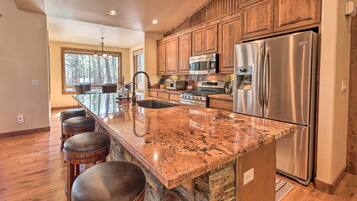 A spacious kitchen with granite countertops, stainless steel appliances, and wooden cabinets.