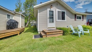 Ett enplanshus på hjul med en liten veranda framtill, ett litet trädäck och ett takförsett grillområde.