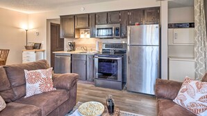 A compact kitchen with modern appliances, a dining area with a sofa, and a living room with a coffee table. - Unit 3 Mi to Branson Strip! Pool, Step-free Access (Branson)