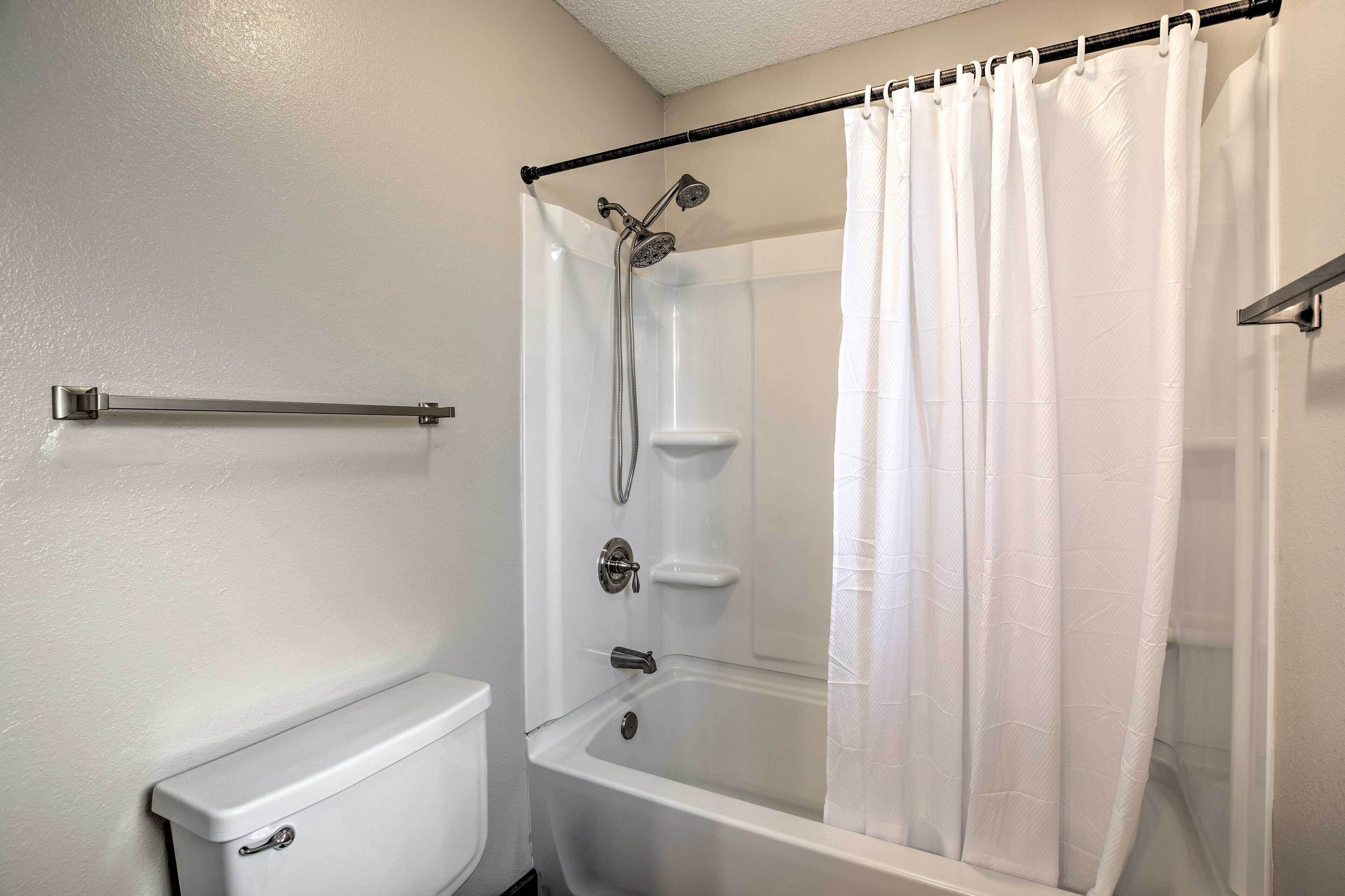 A bathroom with a bathtub, shower, and toilet.