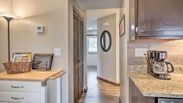 A kitchen with a coffee maker, a basket of magazines, and a framed picture on the counter. - Unit 3 Mi to Branson Strip! Pool, Step-free Access (Branson)