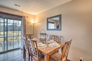 A dining area with a wooden table set for four, surrounded by wooden chairs. - Unit 3 Mi to Branson Strip! Pool, Step-free Access (Branson)