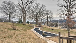 A residential area with a curved driveway, a wooden fence, and houses in the background. - Unit 3 Mi to Branson Strip! Pool, Step-free Access (Branson)