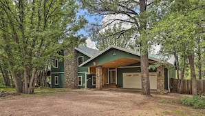 A two-story house with a stone foundation, a garage, and a covered porch. - Deck + Yard: Family-friendly Pinetop Retreat (Pinetop)