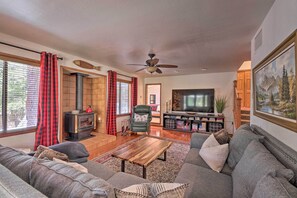 A living room with a sofa, coffee table, and a fireplace. - Deck + Yard: Family-friendly Pinetop Retreat (Pinetop)