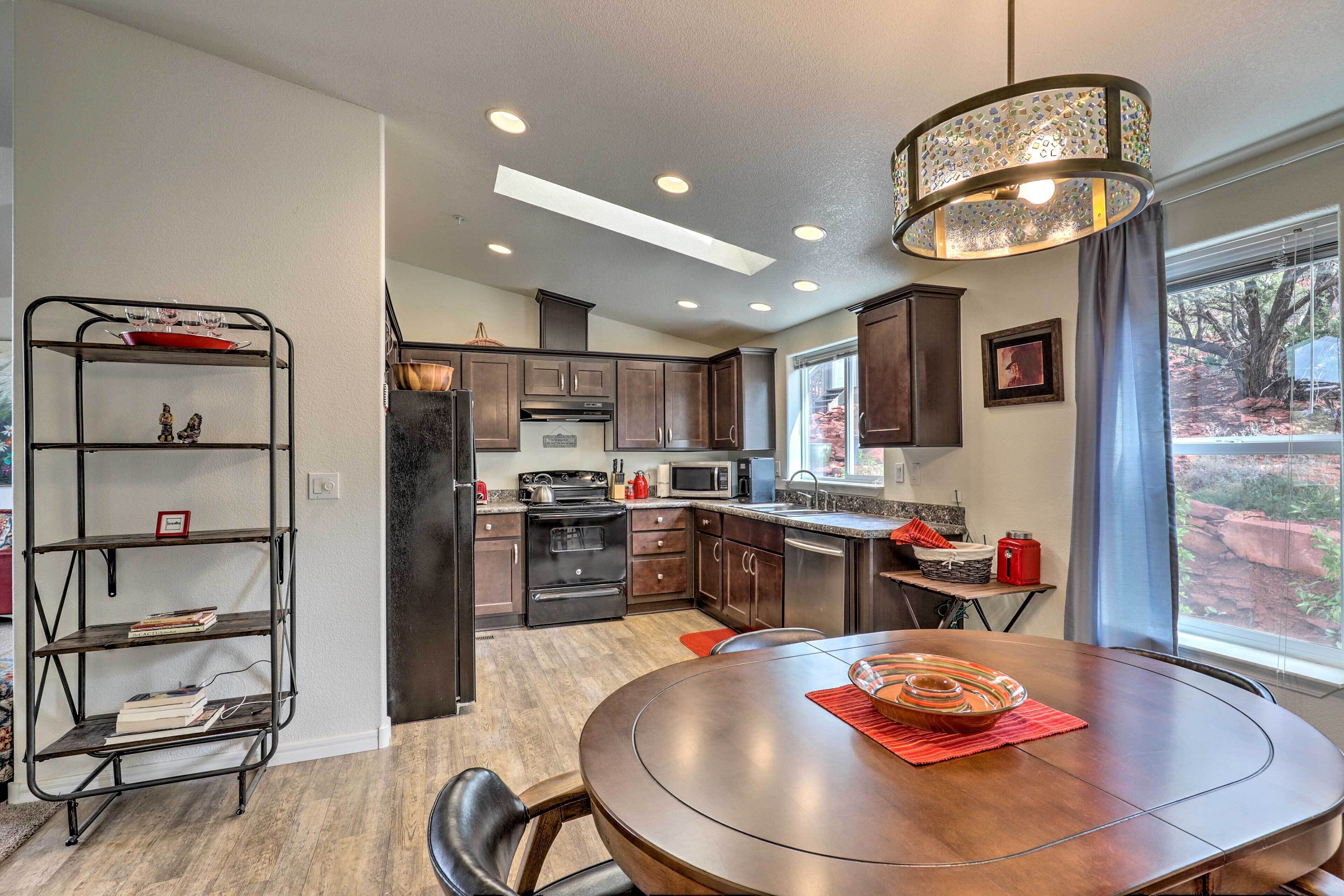 A modern kitchen with dark wood cabinets, a round dining table, and a built-in oven.