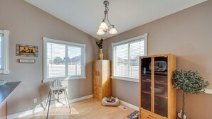 A room with a wooden cabinet, a small plant, a dog bed, and a high chair. - Pet-friendly Nampa Vacation Rental With Yard! (Nampa)