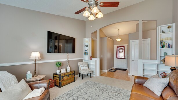 A living room with a brown leather sofa, a patterned rug, a wooden chest, and a ceiling fan. - Pet-friendly Nampa Vacation Rental With Yard! (Nampa)