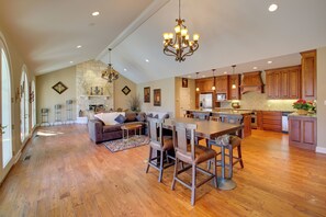 A spacious kitchen with wooden cabinets, a dining area with bar stools, and a fireplace.