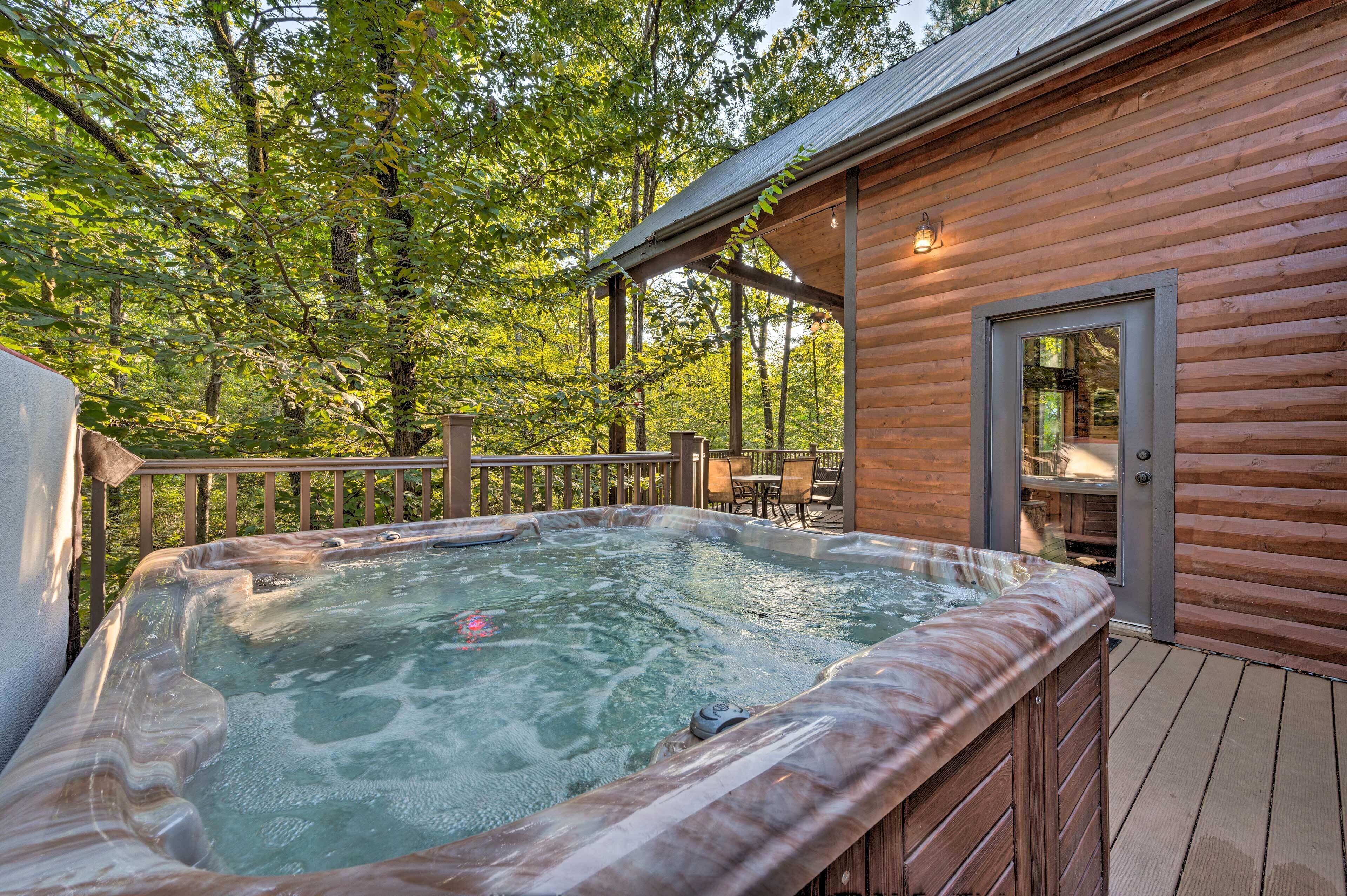 Un jacuzzi en una terraza de madera rodeado de árboles.