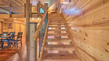 Una scala in legno conduce a un secondo piano, sotto il quale si trova una sala da pranzo.