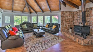 A cozy living room with leather sofas, a coffee table, and a stone fireplace. - Deck & Grill: Camino Home in Wine Country! (Camino)