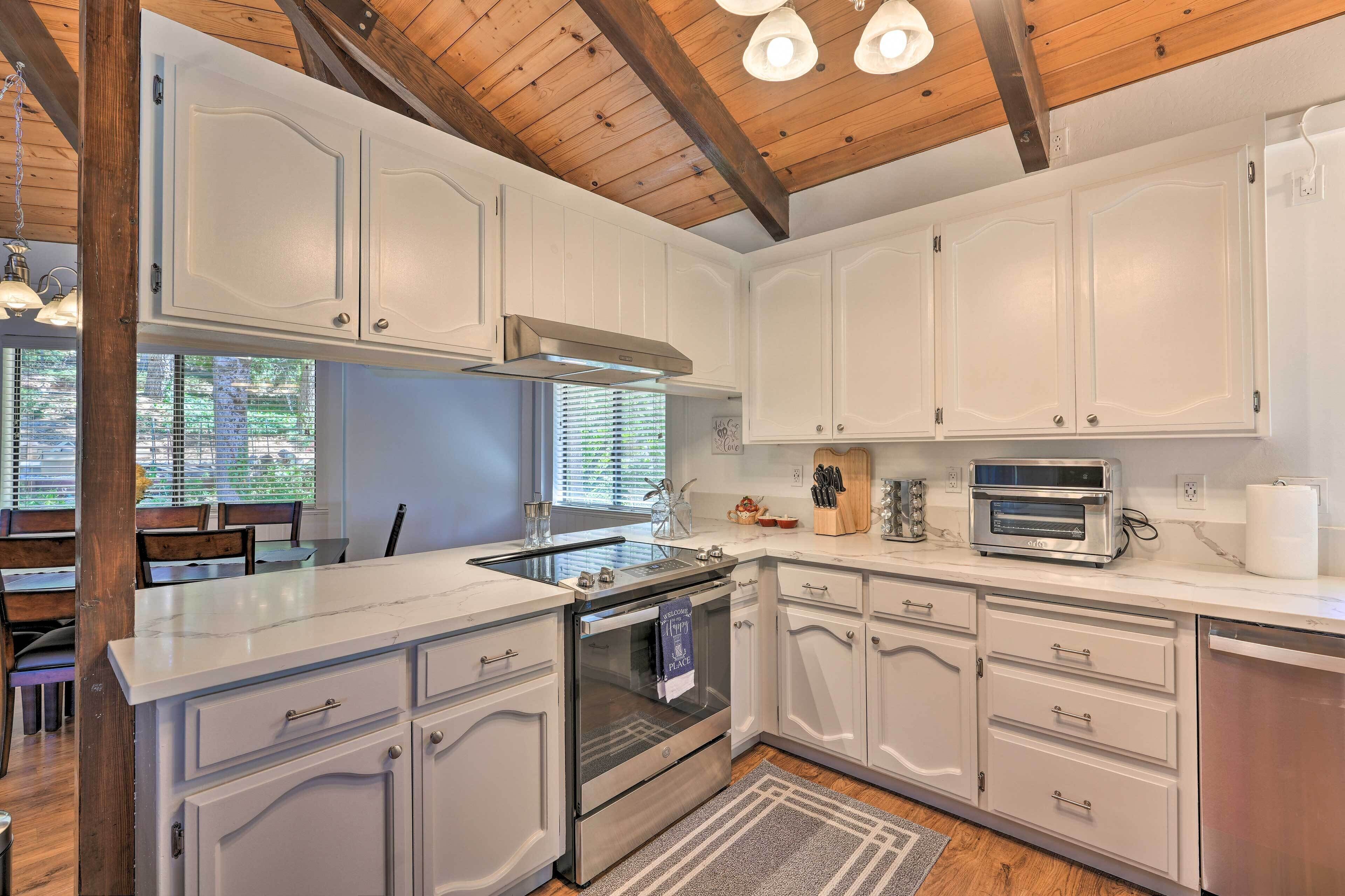 A modern kitchen with white cabinetry, a stainless steel range, and a built-in oven.