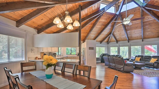 A spacious living area with a wooden ceiling, a dining table with chairs, a sofa, and a ceiling fan. - Deck & Grill: Camino Home in Wine Country! (Camino)