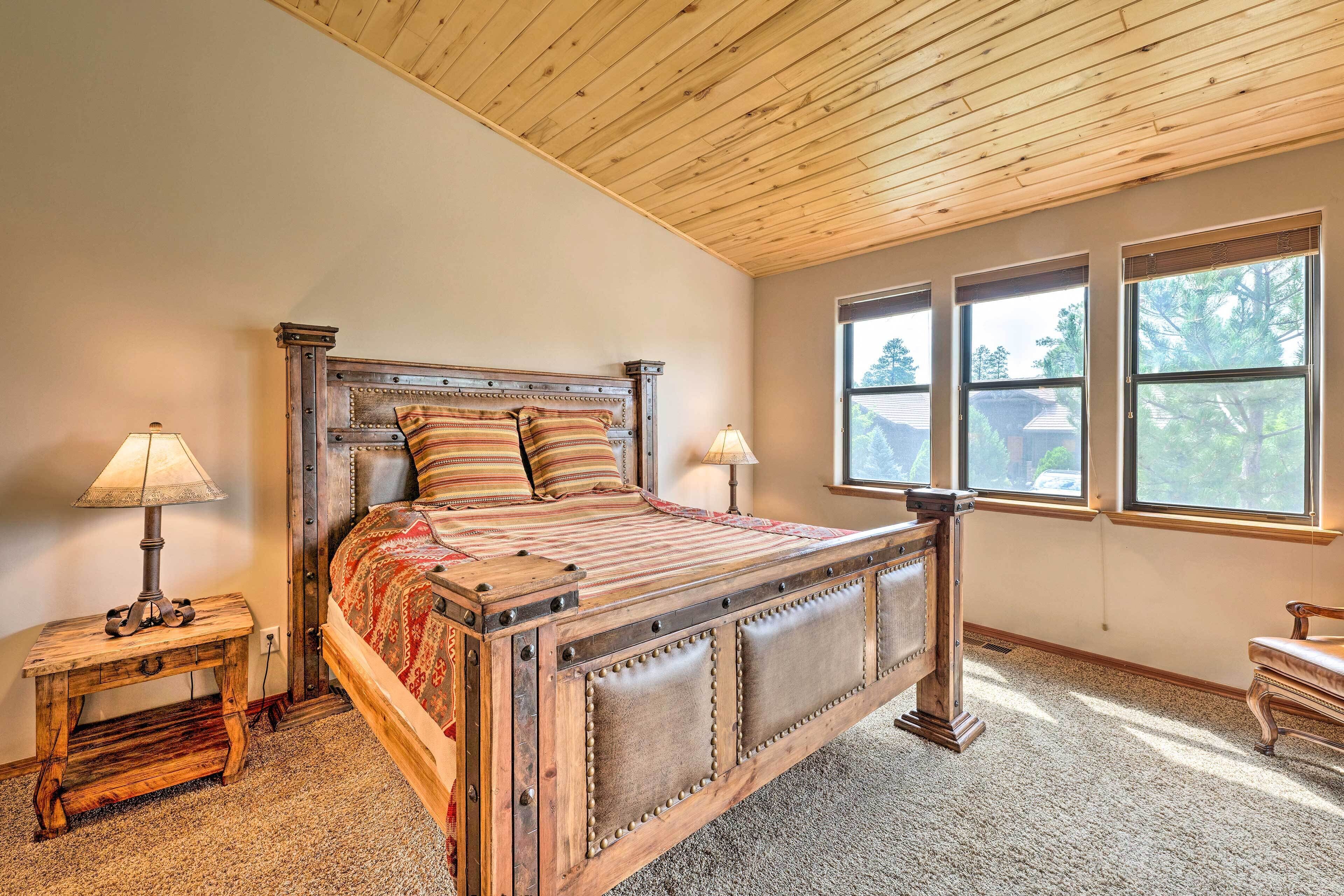 A bedroom with a wooden bed, two bedside tables, and a window with blinds.